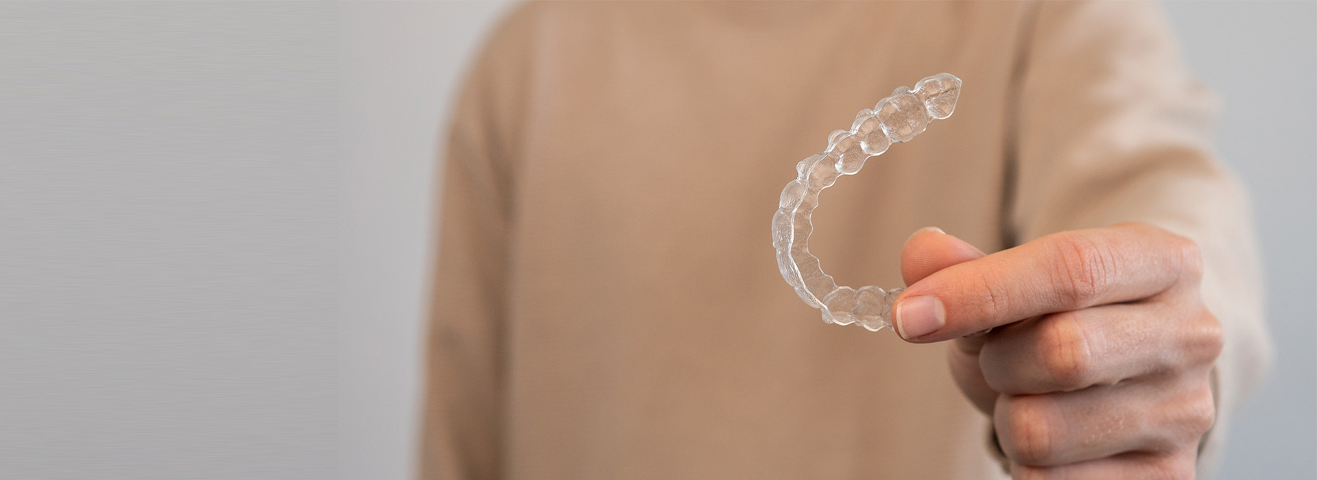 Hand holding a soap bubble against a blurred background.