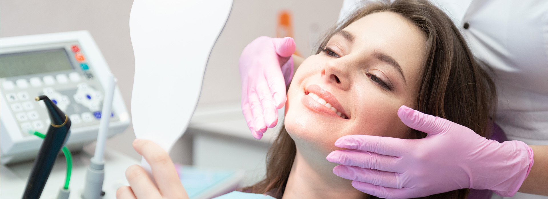 A woman sitting in a dental chair receiving oral care from a professional.